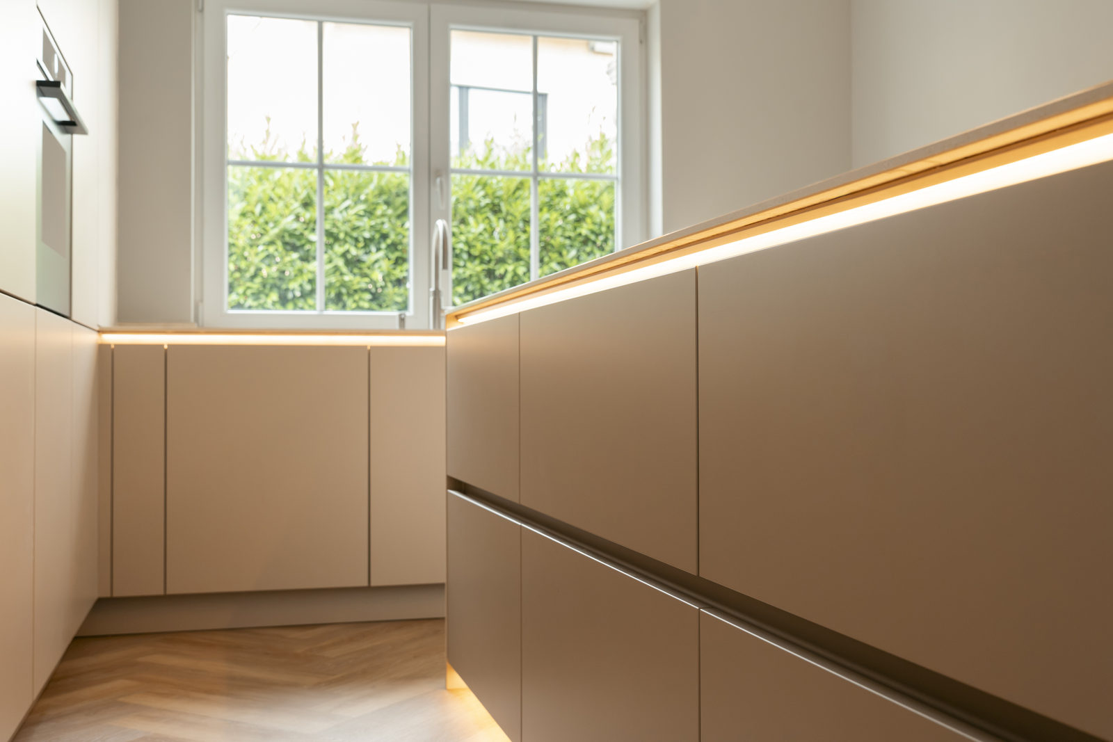 Grifflose Fronten in Yoko Silk mit durchlaufender Kehlleiste und LED-Beleuchtung