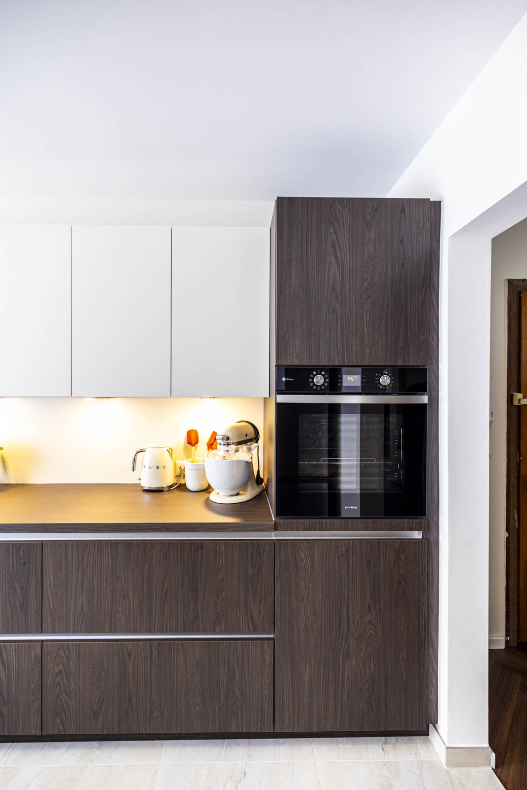 Grifflose Fronten in Dark Maron Holzoptik und Magnolia mit Backofen im Hochschrank