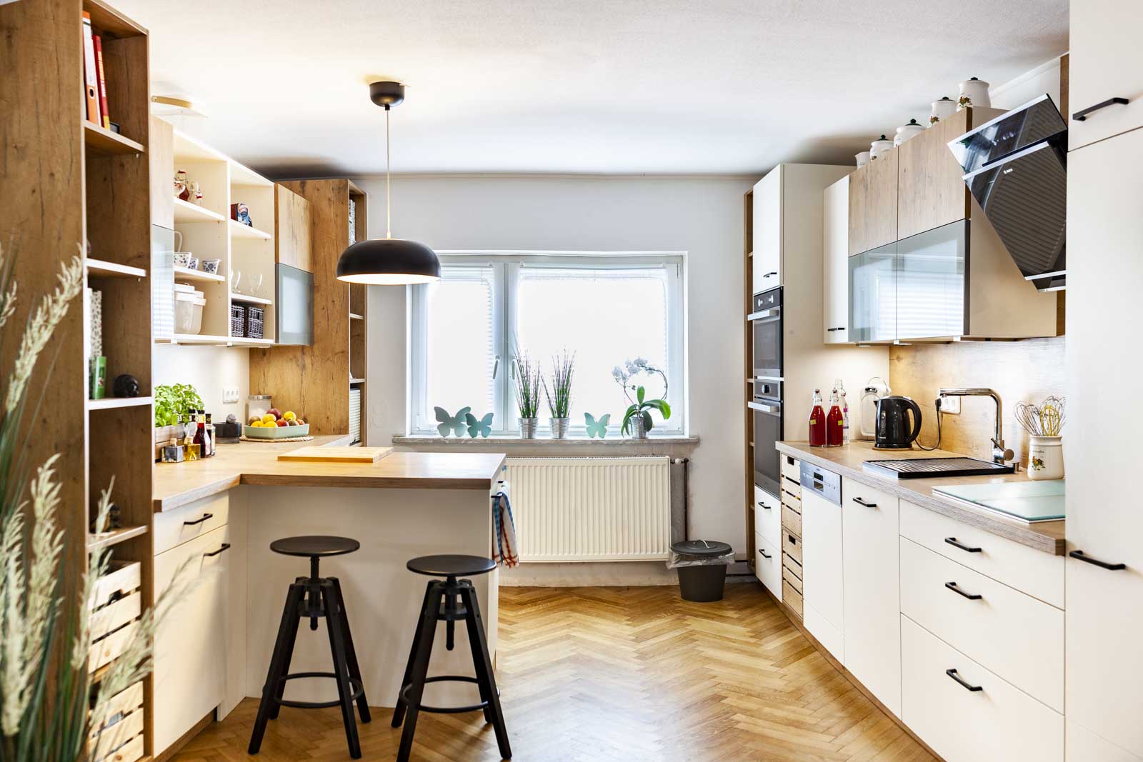Moderne Holz-Landhausküche von Ballerina in Magnolia matt und Castell Eiche mit Halbinsel, Barhockern und schwarzer Dunstabzugshaube