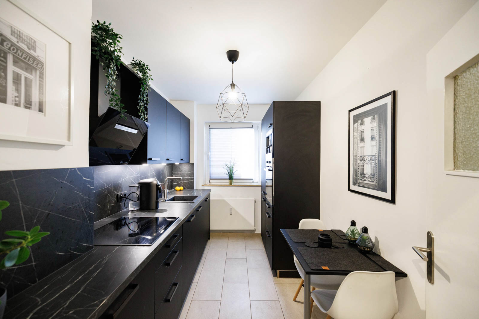 Moderne schwarze Artego-Küchenzeile mit matten Lackfronten, schwarzgrauer Schichtstoff-Arbeitsplatte und Essplatz