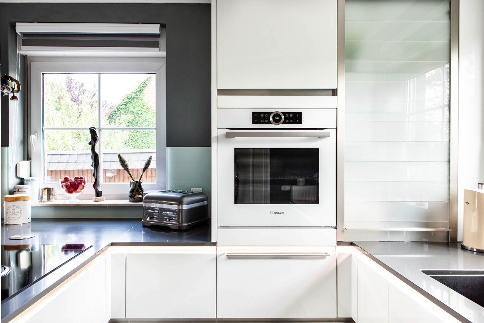 Bosch-Backofen mit Display neben dem Jalousieschrank aus Glas