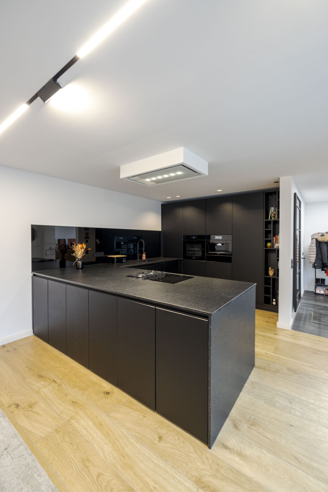 Schwarze grifflose Ballerina-Küche mit Smartglas-Fronten und Nero-Assoluto-Insel