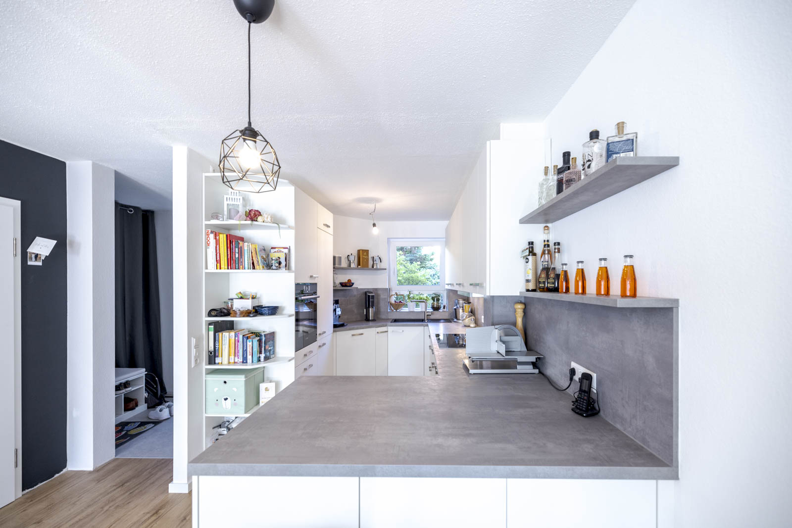 Weiße moderne G-Küche von Ballerina mit Schichtstoff-Arbeitsplatte in Beton Optik Perlgrau, offen zum Wohnbereich