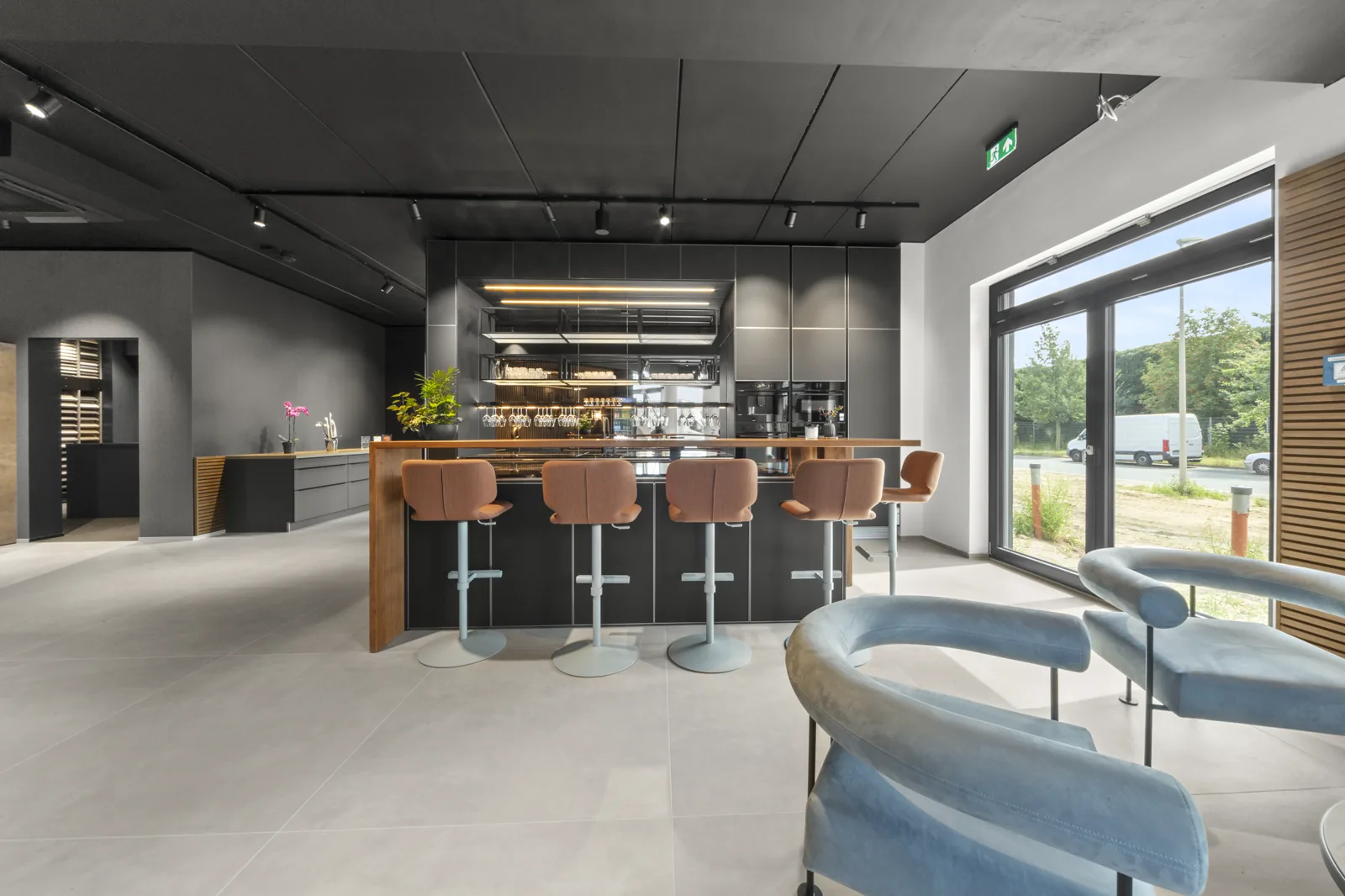 Bartresen mit Barhockern und Loungesesseln am Fenster des Showrooms